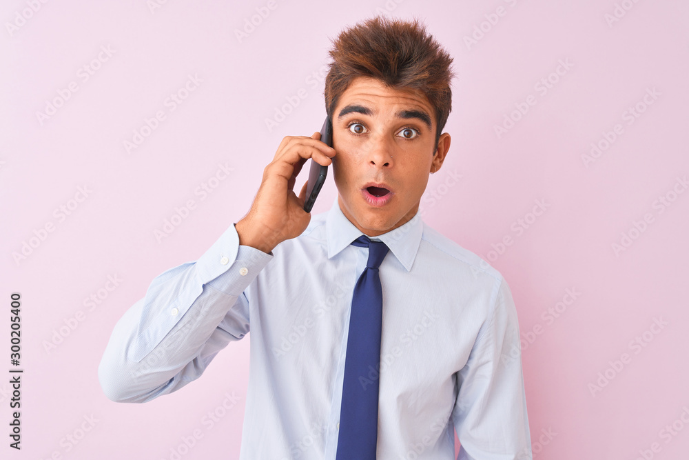 Young handsome businessman talking on the smartphone over isolated pink background scared in shock with a surprise face, afraid and excited with fear expression Young handsome businessman talking on the smartphone over isolated pink background scared in shock with a surprise face, afraid and excited with fear expression