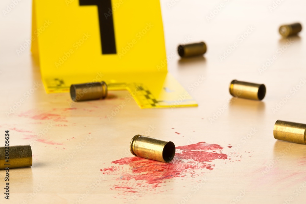 Crime scene investigation CSI evidence marker with empty, fired 9mm bullet  casings on blood covered wood floor background at crime scene - police,  evidence or forensic investigation concept Photos