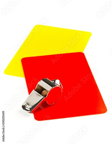 Soccer sports referee yellow and red cards with chrome whistle on white background photo