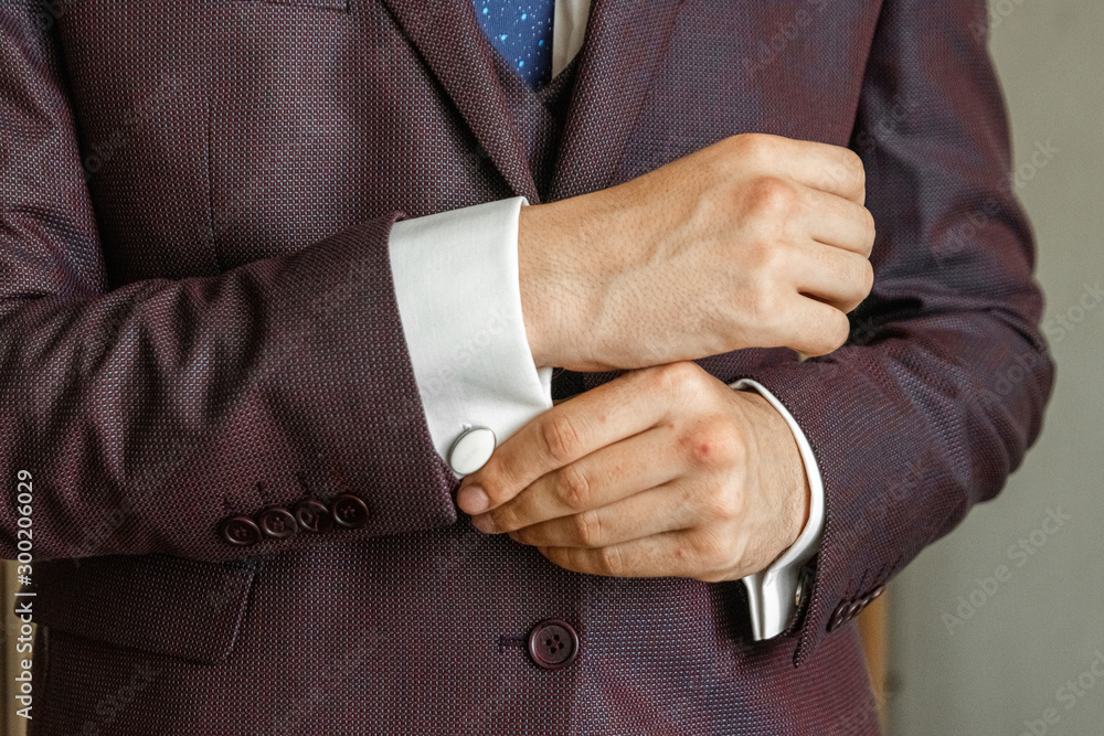 Obraz premium Hands of a businessman, closeup, button sleeves on a shirt.