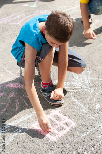 little boyl draws on asphalt