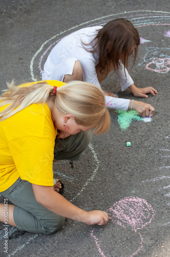 little girls draws on asphalt
