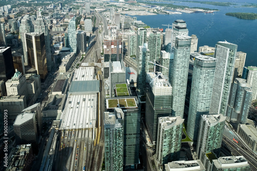 Fototapeta premium Aerial view of Toronto City Skyscrapers, Looking northeast from top of CN Tower toward East York and Scarborough districts in summer, Union Station at bottom right. Toronto City, Ontario, Canada