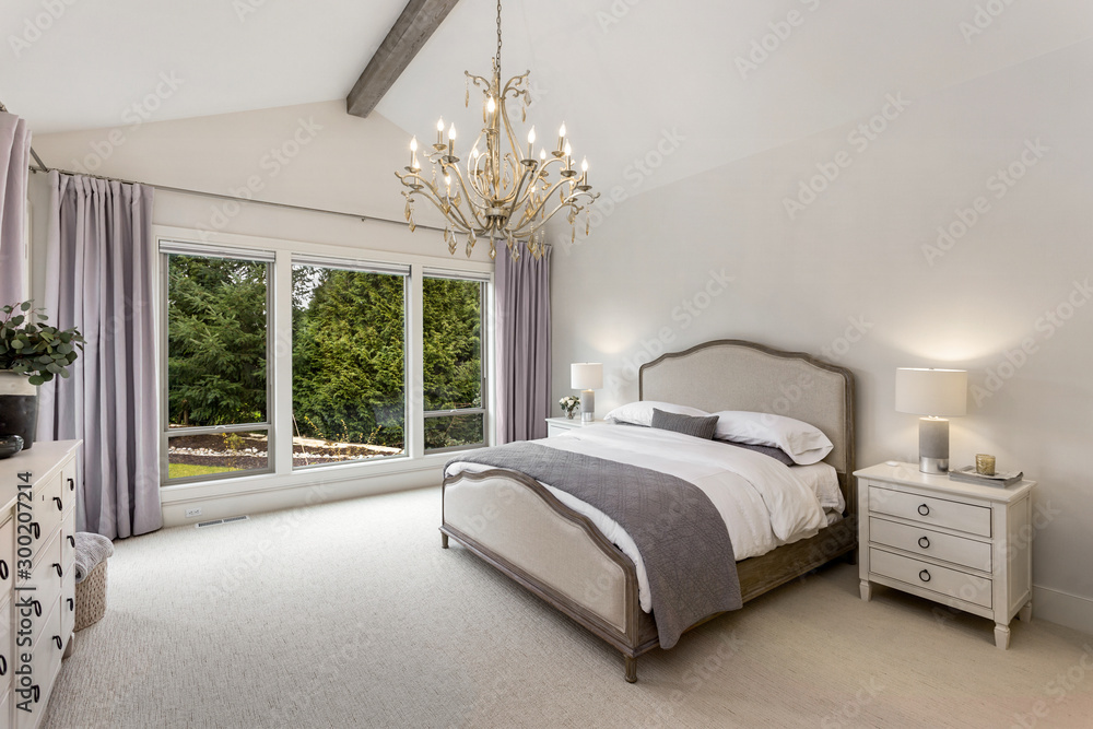 Beautiful bedroom in new luxury home with wood beam and chandelier. - obrazy, fototapety, plakaty 