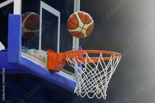A basketball flies into the ring. On the background of a sports complex. Toned