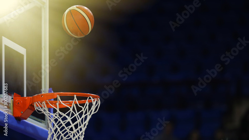 A basketball flies into the ring. On the background of a sports complex. Toned