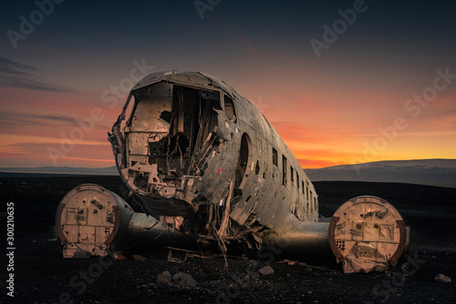 Obraz na płótnie Crushed plane Dakota on black beach at the sunset w salonie