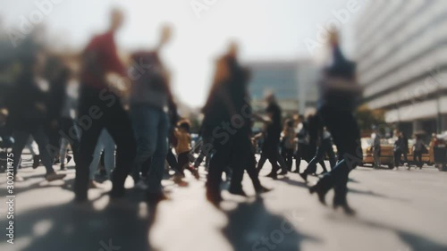 Pedestrians and shoppers commuting in the city on a busy bright day crossing the intersection. No logos trademarks or faces visible.10 bit original BMPCC clip.