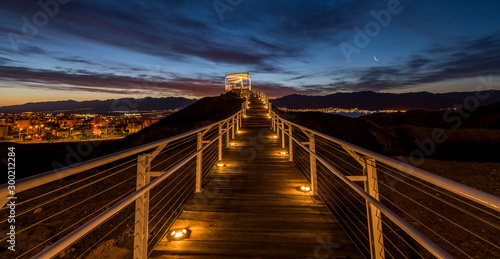 Sunrise at  a top of the mount with illuminated pergola and walkway, public p...