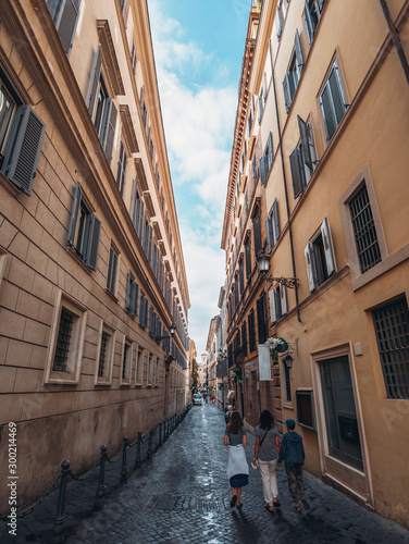 Narrow street and tourists with ancient building of historical center of Rome, Italy. Italian travel concept. © DedMityay