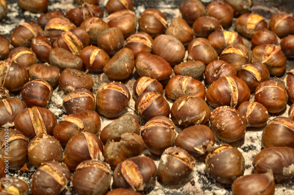 A metal baking pan filled with chestnuts roasted A metal baking pan filled with chestnuts roasted