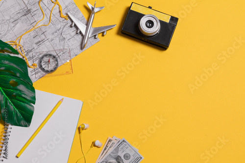 Flat lay traveler accessories on yellow background with blank space for text. Top view travel or vacation concept. Summer background. photo