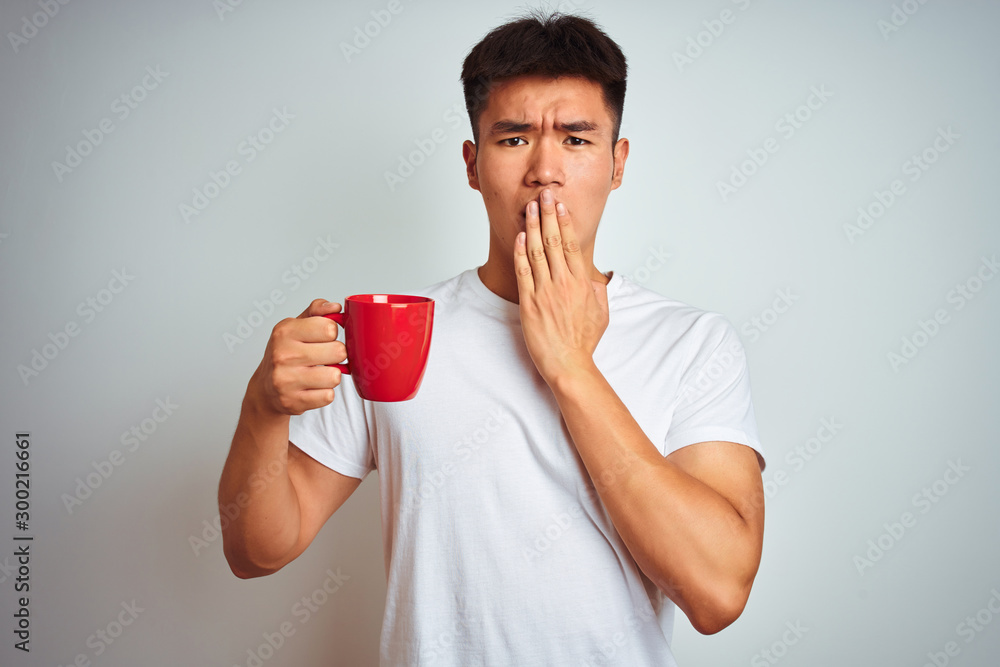 Asian chinese man holding red cup of coffee standing over isolated white background cover mouth with hand shocked with shame for mistake, expression of fear, scared in silence, secret concept Asian chinese man holding red cup of coffee standing over isolated white background cover mouth with hand shocked with shame for mistake, expression of fear, scared in silence, secret concept