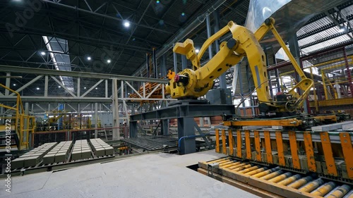 Working arm moves bricks on a line at a modern factory.