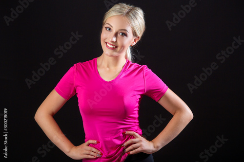 beautiful young woman in sportswear on a black background
