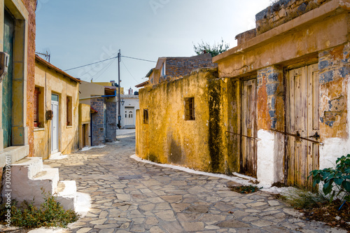 Fototapeta Naklejka Na Ścianę i Meble -  Narrow street with colorful stone houses in the old village of Pano Elounda, Crete, Greece. 