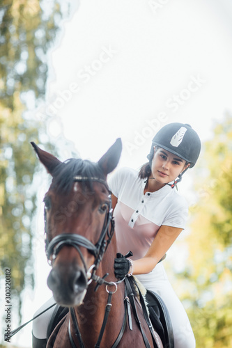 Beautiful girl jockey rides a horse in nature outdoors.