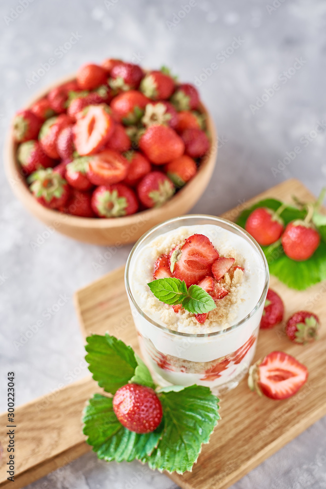 Strawberry granola or smoothie in a glass and fresh berries in wooden bowl, top view. Healthy breakfast Strawberry granola or smoothie in a glass and fresh berries in wooden bowl, top view. Healthy breakfast