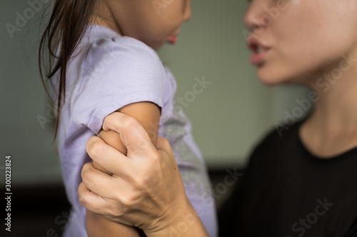 Angry frustrated mother correcting her frightened kid. Child abuse. photo