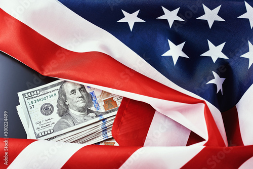 USA national flag and dollar bills on dark background. Finance concept