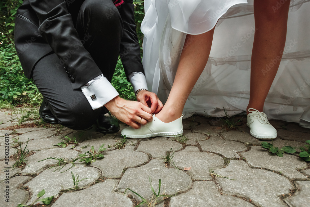 man ties the shoes to the bride. The concept of marriage, family relationships, wedding paraphernalia.
