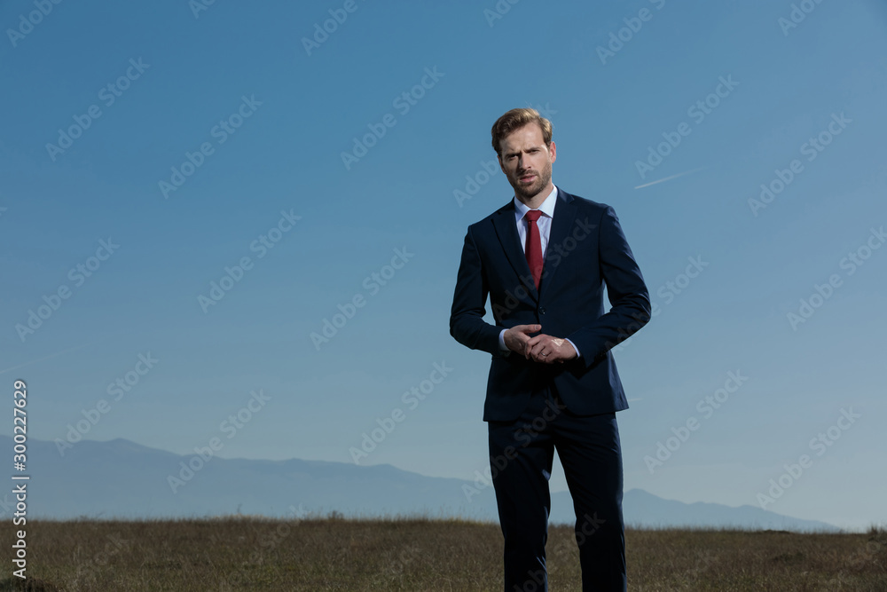 Thoughtful businessman frowning and playing with his hands Thoughtful businessman frowning and playing with his hands