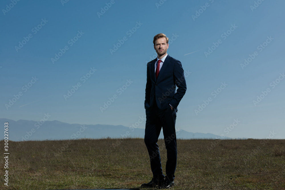 Confident businessman looking away with his hand in his pockets Confident businessman looking away with his hand in his pockets