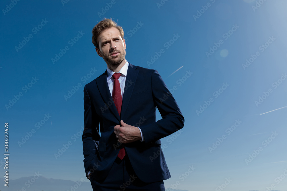 Hopeful businessman unbuttoning his jacket Hopeful businessman unbuttoning his jacket