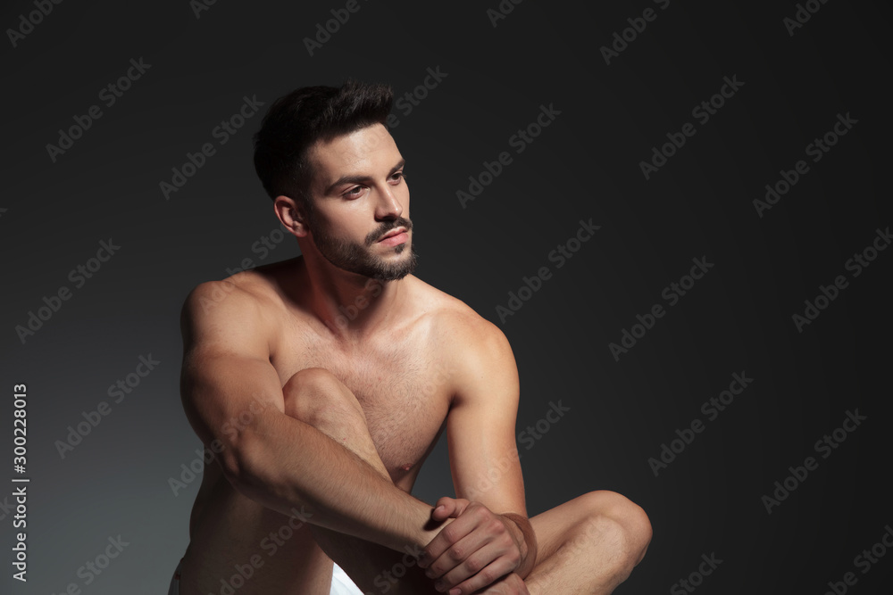thoughtful naked model looking to side and holding hands thoughtful naked model looking to side and holding hands