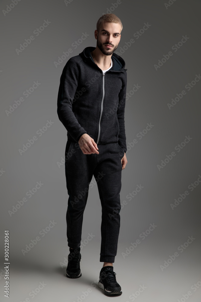 casual man wearing tracksuit walking and staring at camera casual man wearing tracksuit walking and staring at camera