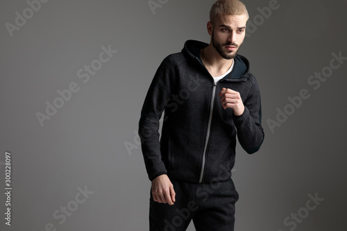 casual man wearing tracksuit standing with loose hands photo