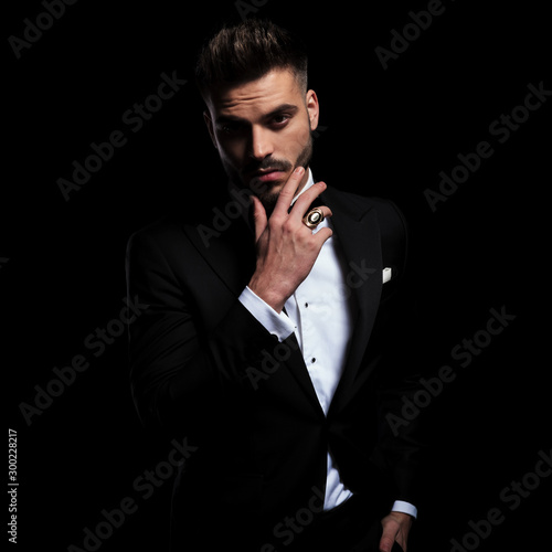 Картината върху платно businessman wearing black suit standing and touching chin pensive