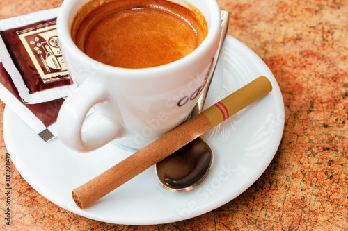 cup of coffee and small cigar on the table. cute bad habits. addiction problem concept