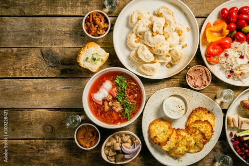 Selection of traditional ukrainian food - borsch, perogies, potato cakes, pickled vegetables, top view photo