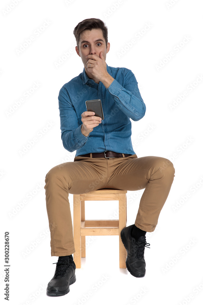 shocked young man covering mouth with hand shocked young man covering mouth with hand