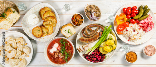 Selection of traditional ukrainian food - borsch, perogies, potato cakes, pickled vegetables, top view