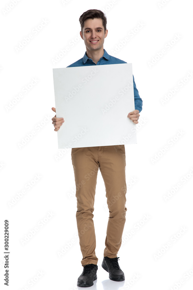 happy young man smiling and holding empty board happy young man smiling and holding empty board