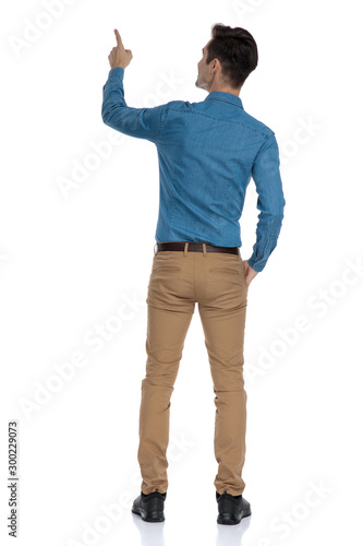 back view of smart casual man looking up and pointing finger