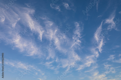 Light cirrus clouds painted across a bright blue sky