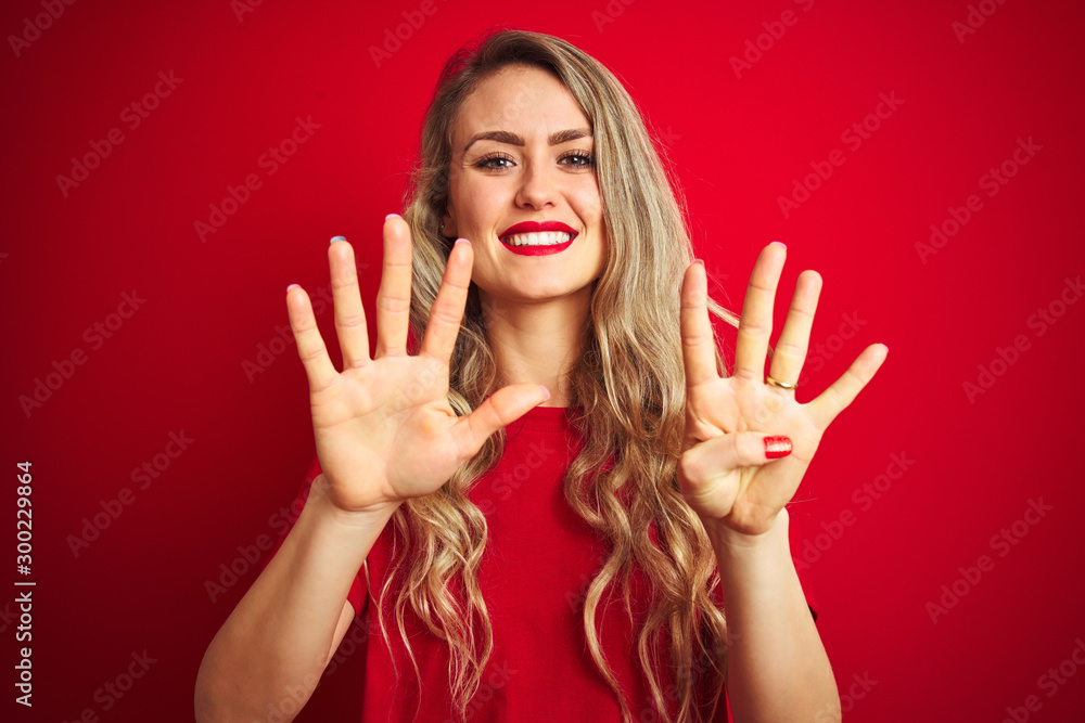 Young beautiful woman wearing basic t-shirt standing over red isolated background showing and pointing up with fingers number nine while smiling confident and happy. Young beautiful woman wearing basic t-shirt standing over red isolated background showing and pointing up with fingers number nine while smiling confident and happy.