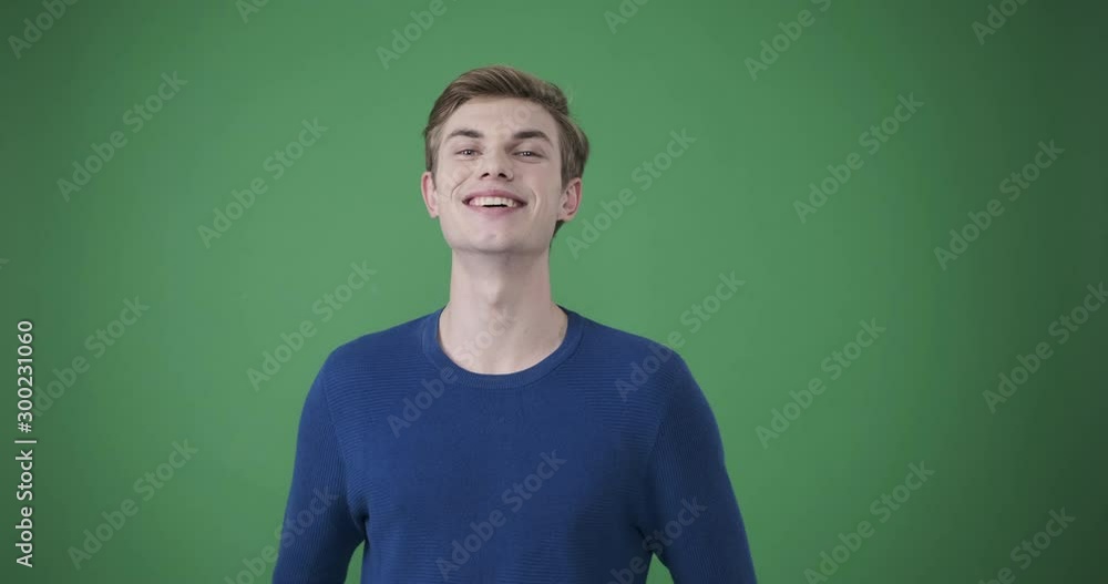 Handsome young man in tshirt smiling over green background Handsome young man in tshirt smiling over green background