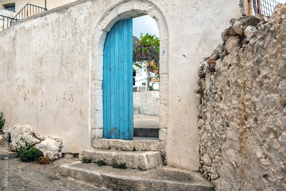 Opened door in old abandoned wall, Crete island, Greece