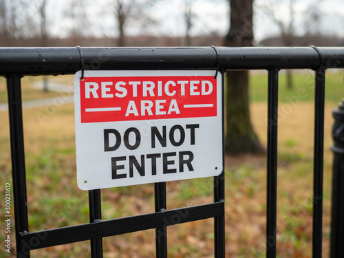 Restricted area do not enter sign hung on black gate photo