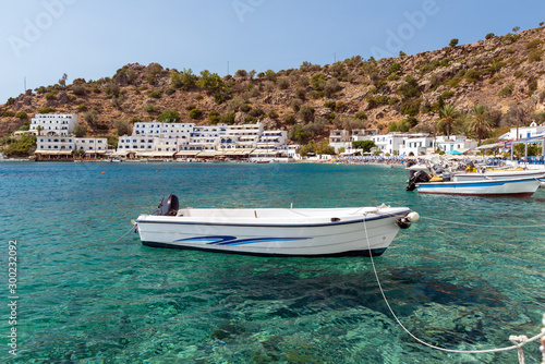 Mały motorboat przy jasną wody zatoką Loutro miasteczko na Crete wyspie, Grecja