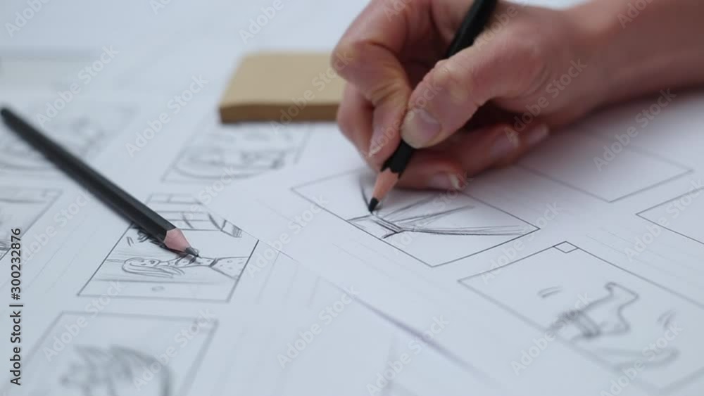 Hands draw with a pencil the storyboard for the film. Hands draw with a pencil the storyboard for the film.