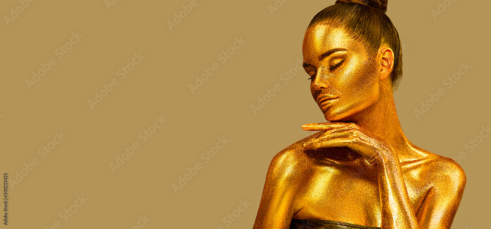 Golden sparkles skin, Woman face portrait closeup. Model girl with holiday golden Glamour shiny professional make up. Gold jewellery, jewelry, accessories. Beauty gold metallic body, fashion Xmas art. Golden sparkles skin, Woman face portrait closeup. Model girl with holiday golden Glamour shiny professional make up. Gold jewellery, jewelry, accessories. Beauty gold metallic body, fashion Xmas art.