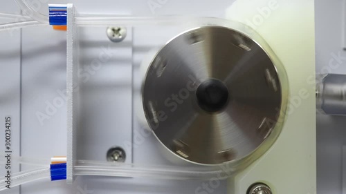 Peristaltic pump with plastic tubes pumping fluid.