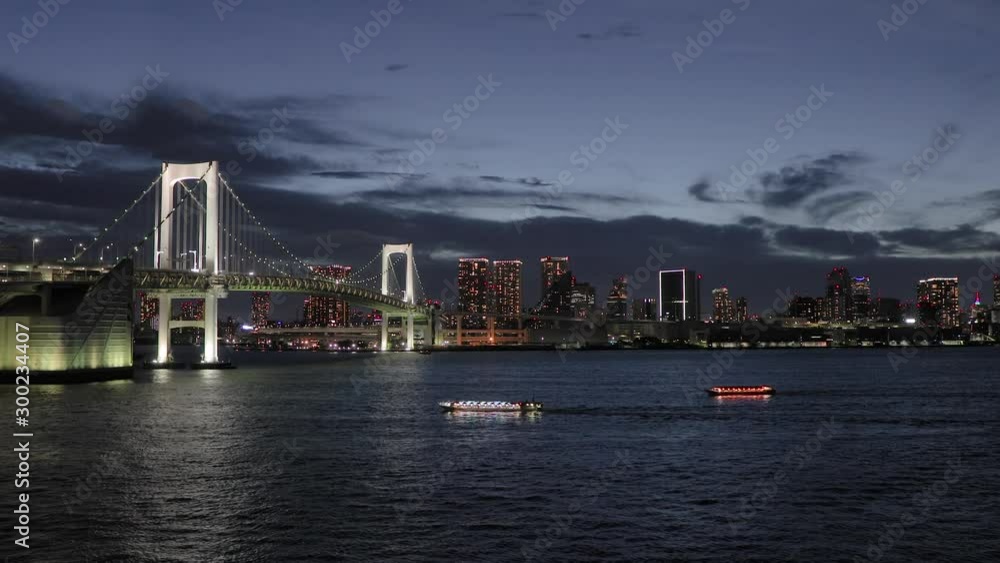 Tokyo Rainbow bridge at night crossing Tokyo Bay water with tourist sightseeing boats Tokyo Rainbow bridge at night crossing Tokyo Bay water with tourist sightseeing boats
