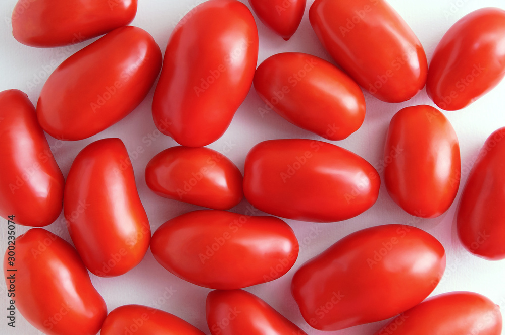 Red plum variety tomatoes on a white background. View from above. Red plum variety tomatoes on a white background. View from above.