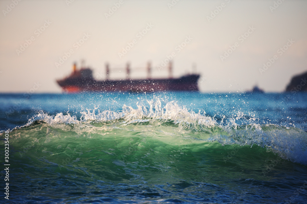 Fototapeta premium Sailing cargo ship and waves at sunrise. Transportation. Logistics. Shipping.